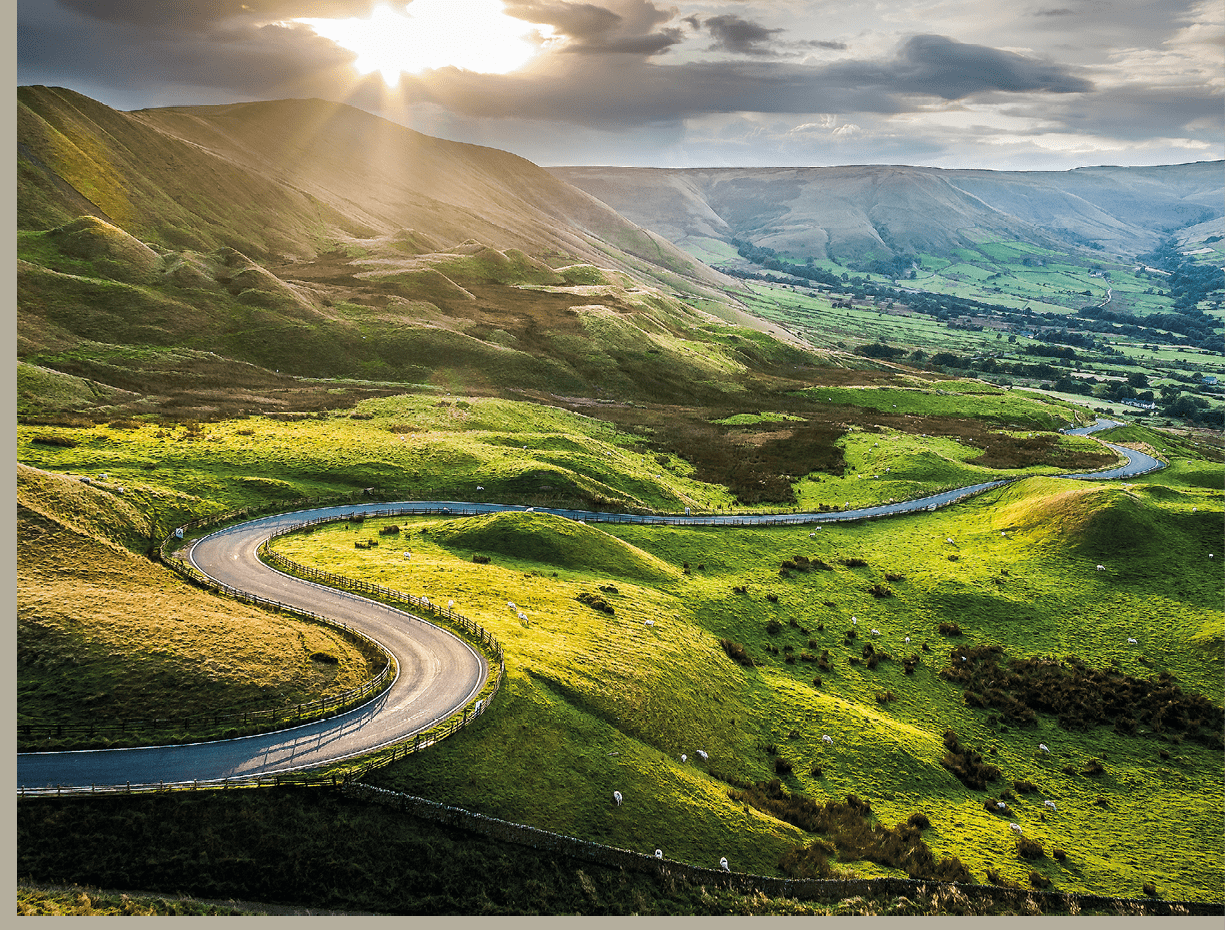 Sunset at Mam Tor, Peak District National Park, with a view along the winding road among the green hills down to Hope Valley, in Derbyshire, England.; Shutterstock ID 719075554; cislo_zakazky: -; klient: -; Prevod_licence_na : -; Ostatni: -